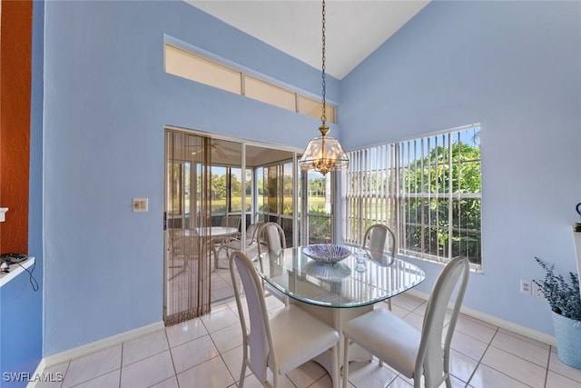 dining room featuring high vaulted ceiling, baseboards, and light tile patterned floors