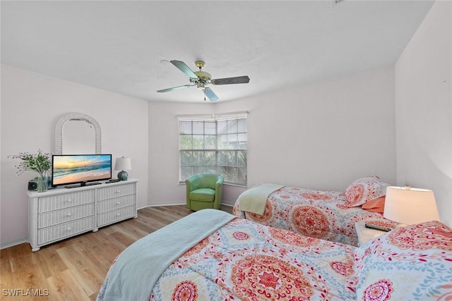 bedroom featuring ceiling fan, baseboards, and wood finished floors