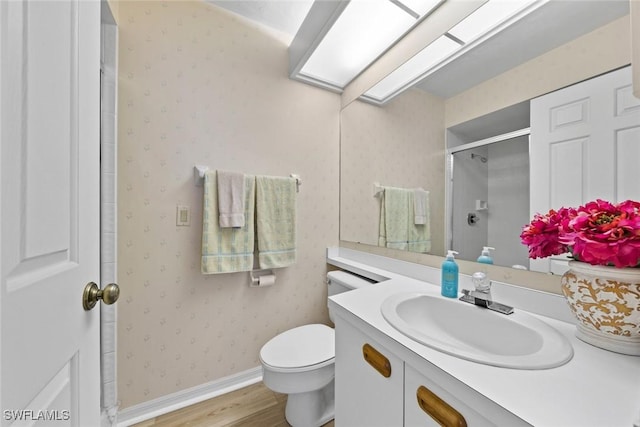 full bath with wallpapered walls, a skylight, a stall shower, toilet, and wood finished floors