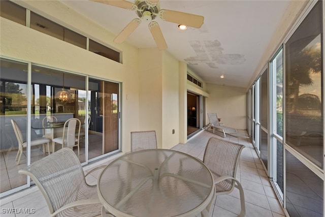 sunroom / solarium with ceiling fan with notable chandelier