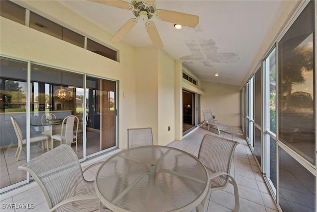 sunroom featuring ceiling fan with notable chandelier and plenty of natural light