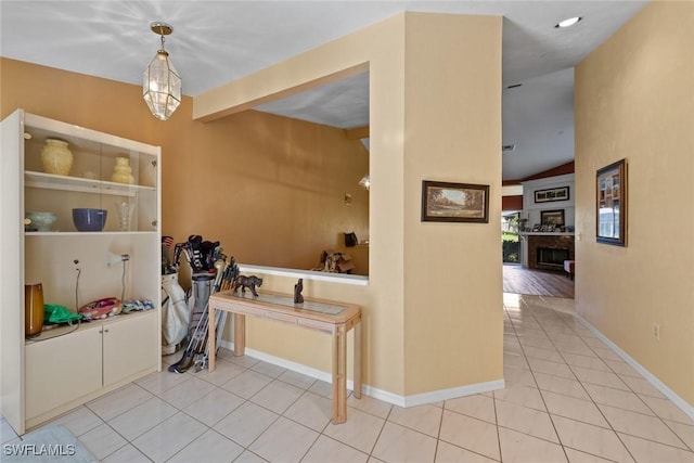 interior space featuring baseboards, vaulted ceiling with beams, and tile patterned floors