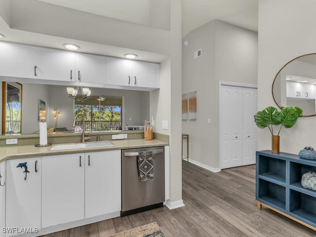 kitchen with a notable chandelier, sink, stainless steel dishwasher, and white cabinets