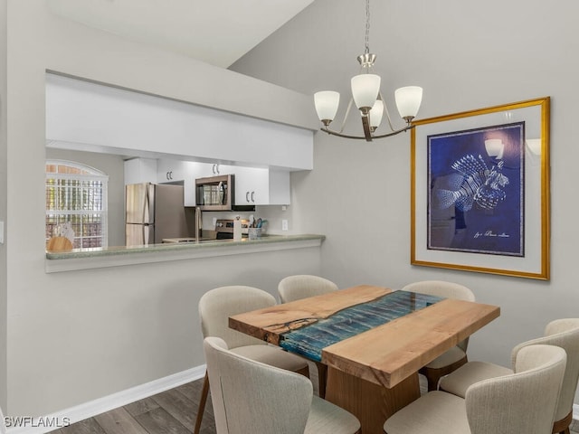 dining area featuring dark wood-type flooring and a chandelier