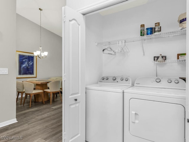 laundry room featuring hardwood / wood-style flooring, washer and clothes dryer, and a notable chandelier