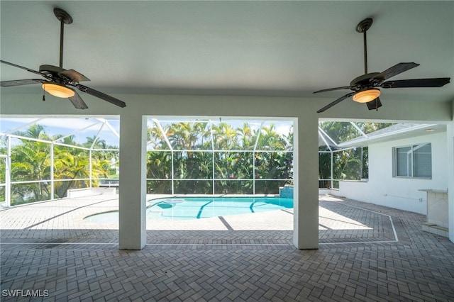 view of pool with ceiling fan, a lanai, and a patio