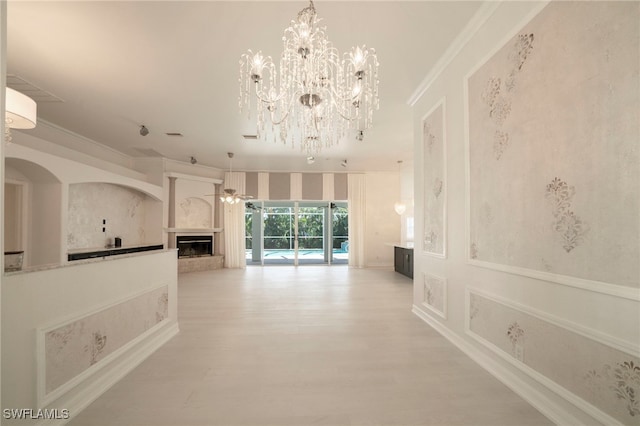 interior space with crown molding, light wood-type flooring, and a chandelier