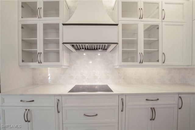 kitchen with black electric cooktop, white cabinetry, and decorative backsplash