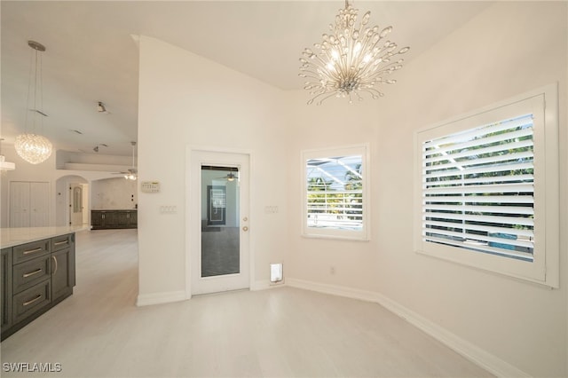 empty room with ceiling fan with notable chandelier