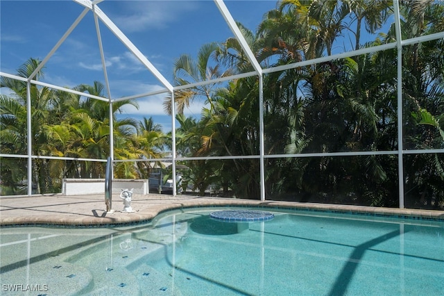 view of swimming pool featuring a lanai and a patio