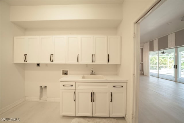 interior space featuring cabinets, light hardwood / wood-style floors, electric dryer hookup, hookup for a washing machine, and sink