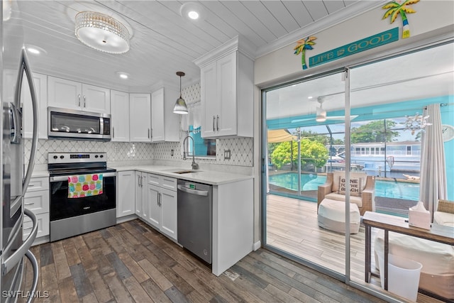 kitchen with appliances with stainless steel finishes, sink, white cabinets, dark hardwood / wood-style flooring, and decorative backsplash