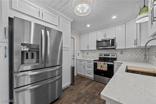 kitchen featuring stainless steel appliances, white cabinetry, tasteful backsplash, and decorative light fixtures