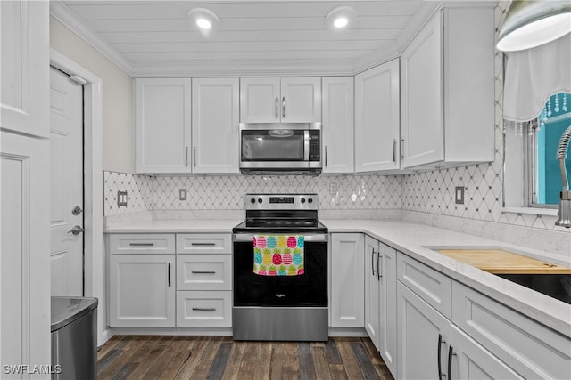 kitchen featuring dark wood-type flooring, white cabinetry, light stone counters, appliances with stainless steel finishes, and decorative backsplash