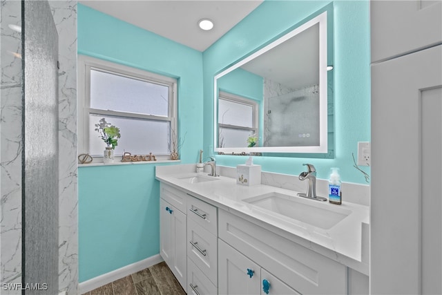 bathroom featuring hardwood / wood-style flooring, vanity, and a shower