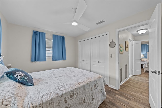 bedroom with hardwood / wood-style flooring, ceiling fan, and a closet