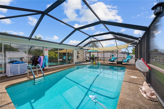 view of pool with a patio area and glass enclosure