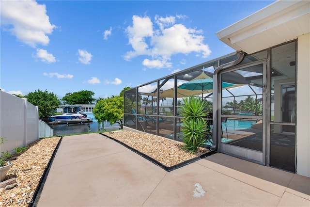 view of patio / terrace with a lanai and a water view