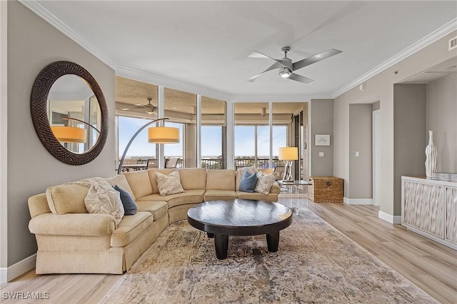 living room with ceiling fan, light wood-type flooring, and crown molding