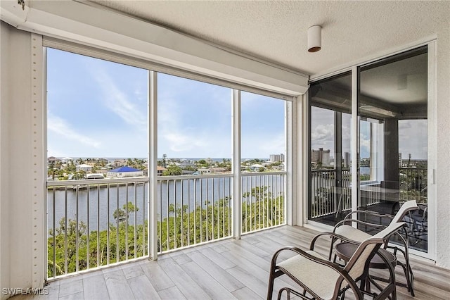 sunroom featuring a water view