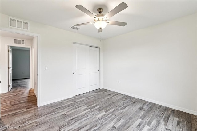 unfurnished bedroom featuring ceiling fan, a closet, and light wood-type flooring