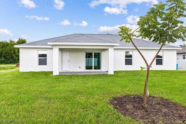 rear view of property featuring a lawn