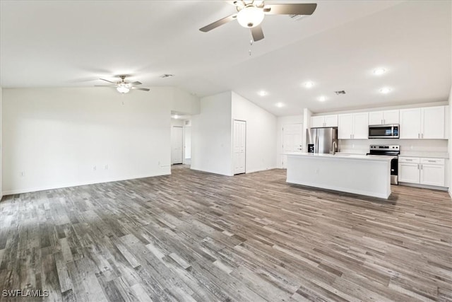 kitchen featuring white cabinetry, light wood-type flooring, a kitchen island, and appliances with stainless steel finishes