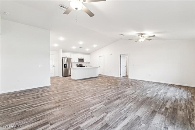 unfurnished living room featuring ceiling fan, lofted ceiling, and light hardwood / wood-style floors