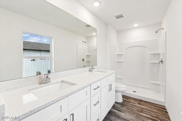 bathroom with vanity, wood-type flooring, toilet, and a shower