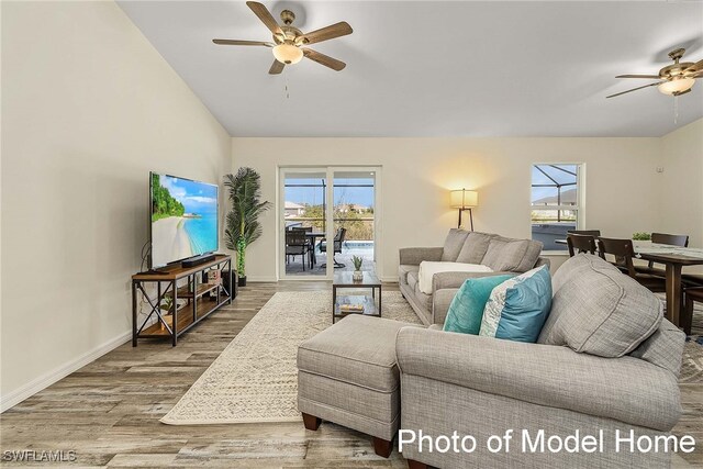 living room featuring vaulted ceiling, ceiling fan, and hardwood / wood-style floors