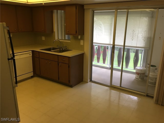 kitchen with light tile patterned floors, tasteful backsplash, white appliances, and sink