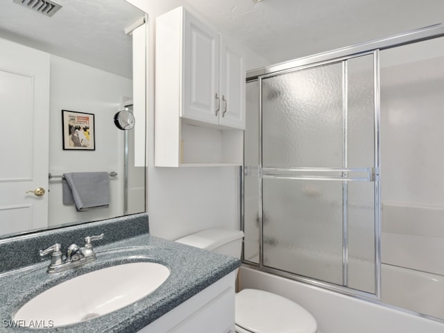 full bathroom with vanity, shower / bath combination with glass door, and toilet