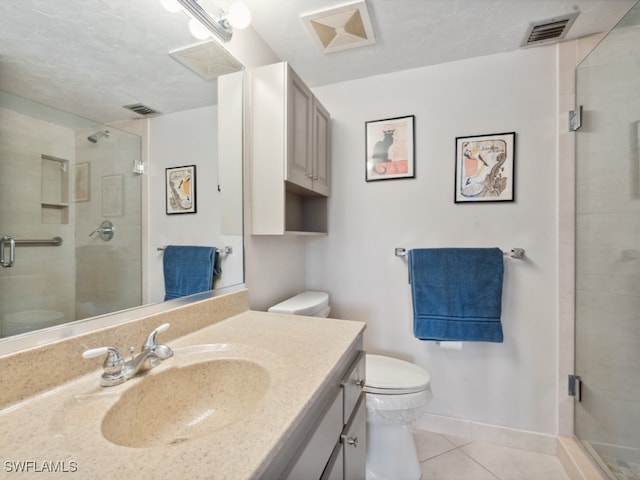 bathroom featuring vanity, toilet, tile patterned flooring, and walk in shower