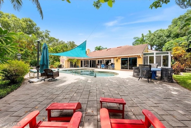 view of pool with a patio area and a sunroom