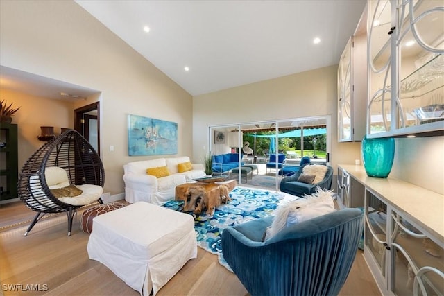 living room featuring high vaulted ceiling and light hardwood / wood-style flooring