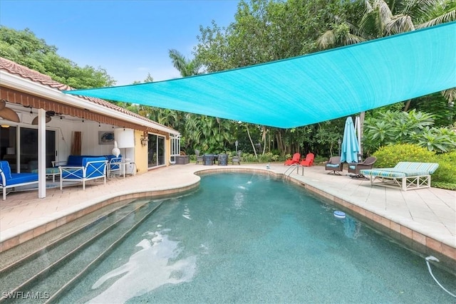 view of swimming pool featuring ceiling fan and a patio