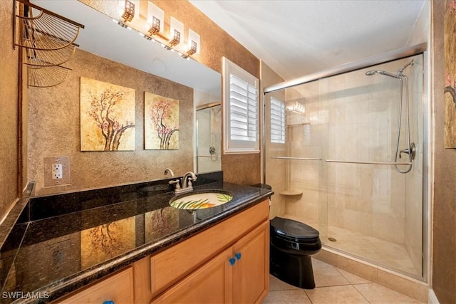 bathroom with tile patterned flooring, vanity, toilet, and walk in shower