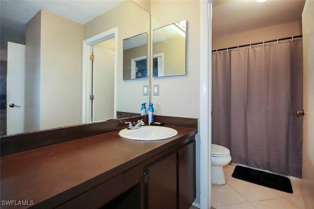 bathroom with a shower with curtain, vanity, toilet, and tile patterned floors