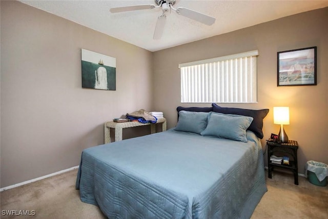 carpeted bedroom with ceiling fan and baseboards