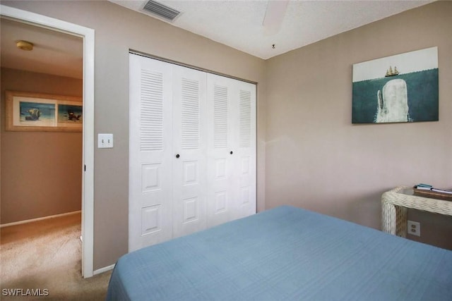 bedroom with baseboards, visible vents, ceiling fan, carpet flooring, and a closet