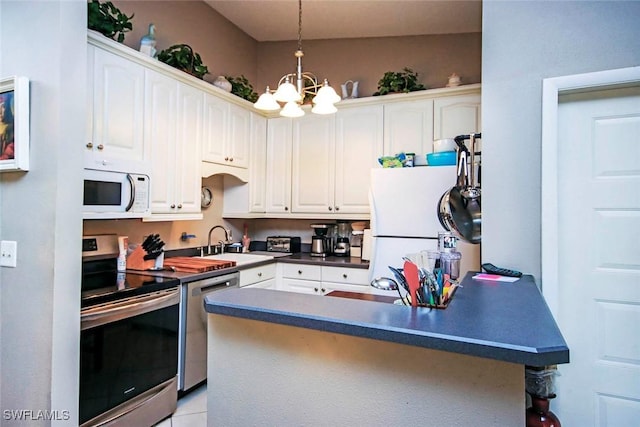 kitchen featuring dark countertops, white cabinets, stainless steel appliances, and a sink