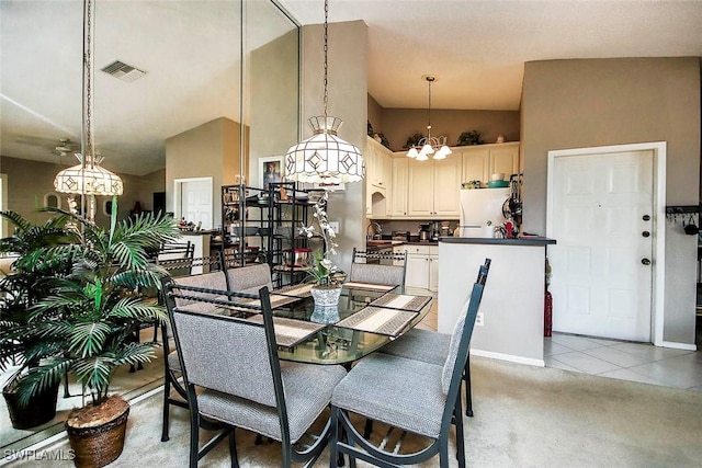 dining space featuring a chandelier, light tile patterned floors, light carpet, a high ceiling, and visible vents