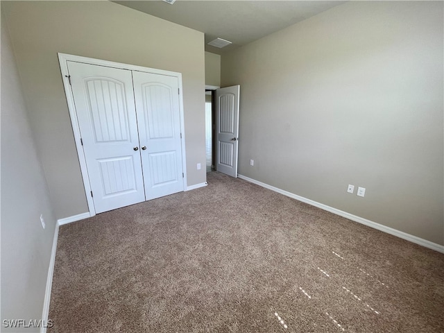 unfurnished bedroom with a closet and carpet floors