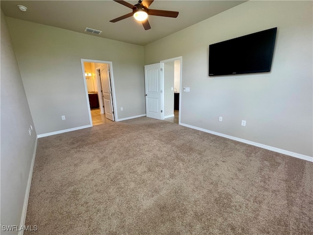 unfurnished bedroom with ensuite bath, light carpet, and ceiling fan