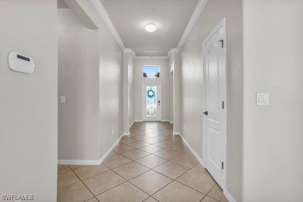 entryway featuring crown molding, baseboards, and light tile patterned floors