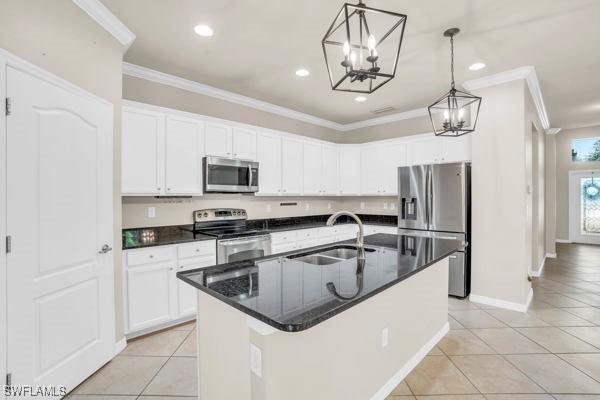 kitchen with a center island with sink, stainless steel appliances, light tile patterned floors, and sink