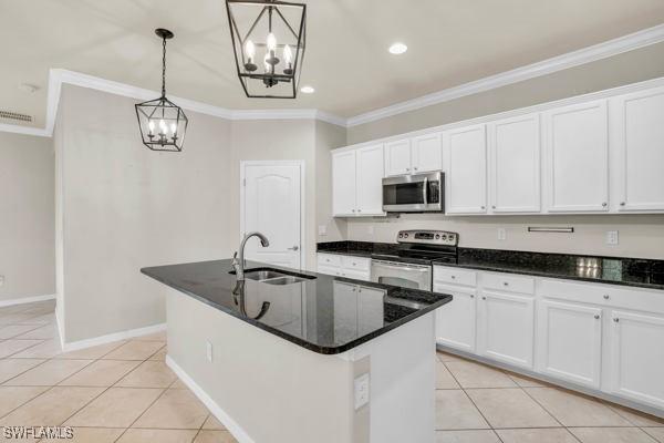 kitchen featuring white cabinetry, a kitchen island with sink, hanging light fixtures, appliances with stainless steel finishes, and sink