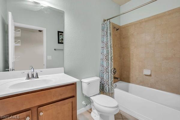 full bathroom with tile patterned floors, vanity, shower / bath combo with shower curtain, and toilet