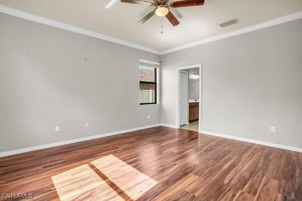 unfurnished room with ornamental molding, wood finished floors, visible vents, and baseboards