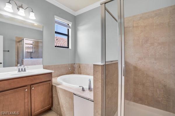 bathroom featuring separate shower and tub, crown molding, and vanity